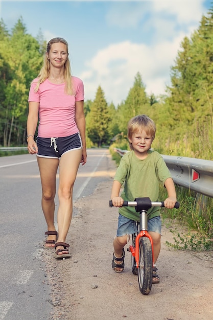 Maman active marchant avec un enfant à vélo