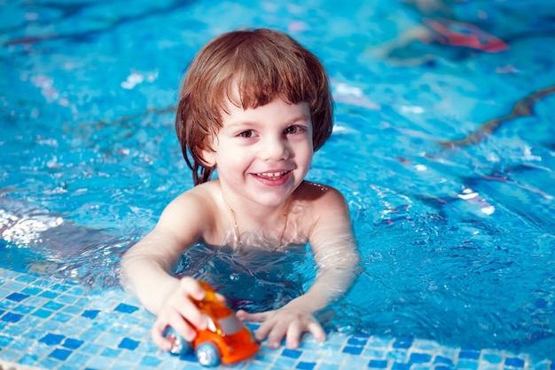 Maman apprend à un enfant à nager dans la piscine