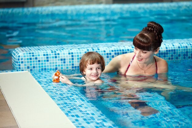 Maman apprend à un enfant à nager dans la piscine