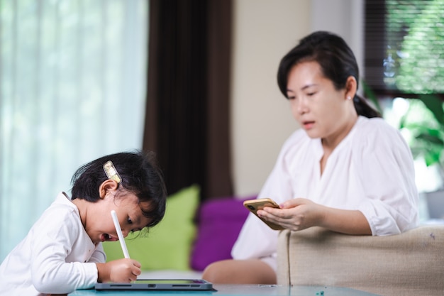 Maman apprend à ses filles à étudier en ligne à la maison