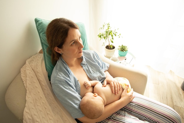 Maman et bébé au fauteuil Allaitement en position berceau