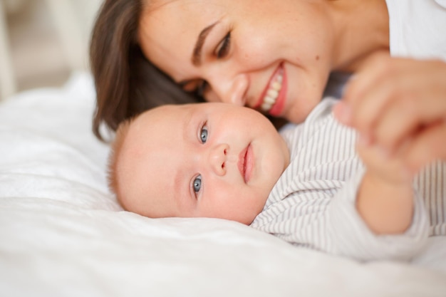 Maman et bébé sont allongés à la maison sur le lit