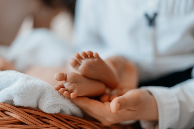 Maman caressant doucement les jambes de son nouveau-né