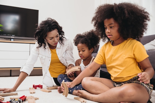 Maman célibataire avec deux fille jouant jouet dans l'appartement