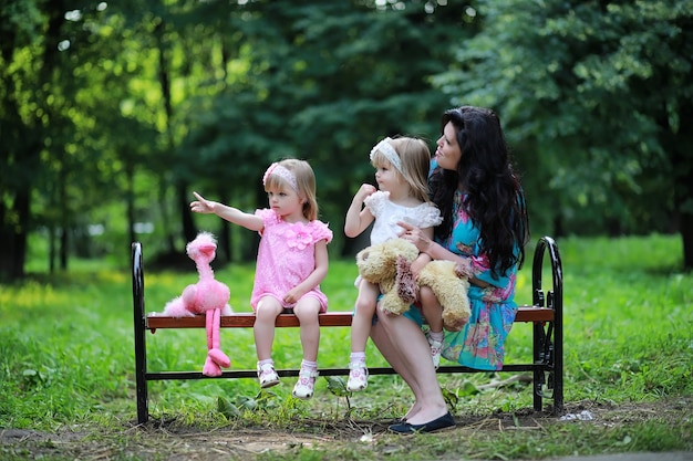 Maman avec deux filles jumelles pour une promenade dans le parc