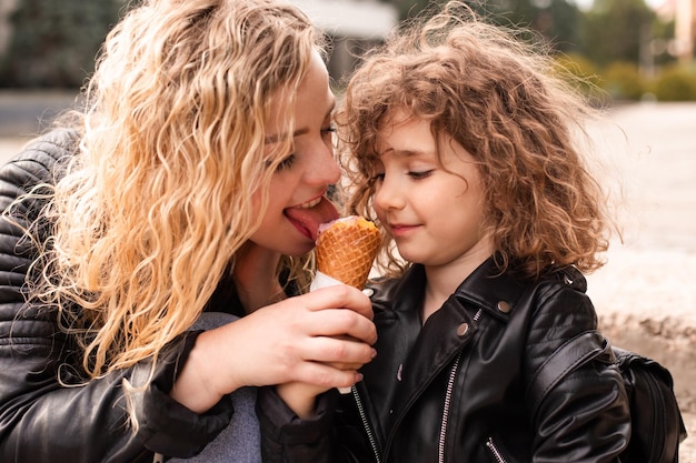 La maman donne à sa fille un essai de glace