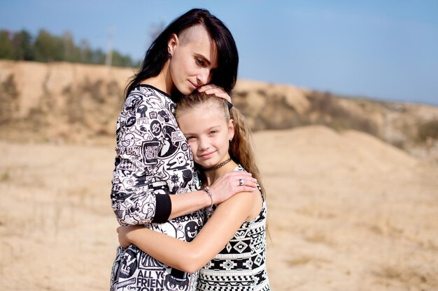 Maman embrasse sa fille et lui caresse les cheveux