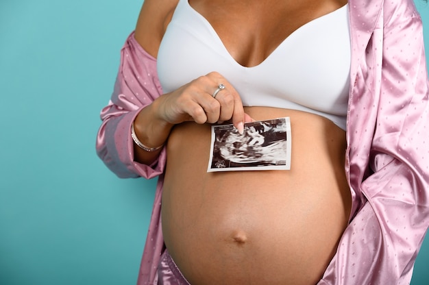 Maman enceinte montre une échographie de son fils