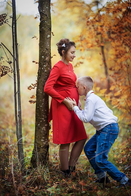 Maman enceinte et son fils dans le parc en automne