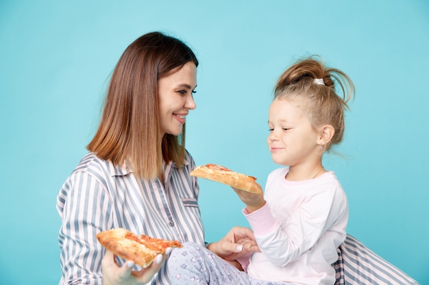 Maman et enfant mangeant de la pizza ensemble le matin