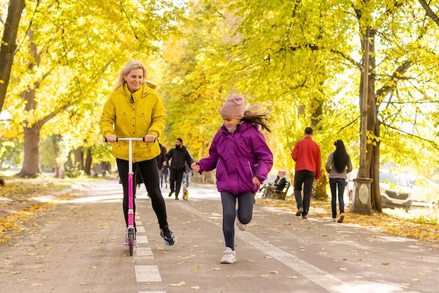 Maman et enfant avec un scooter dans la rue,