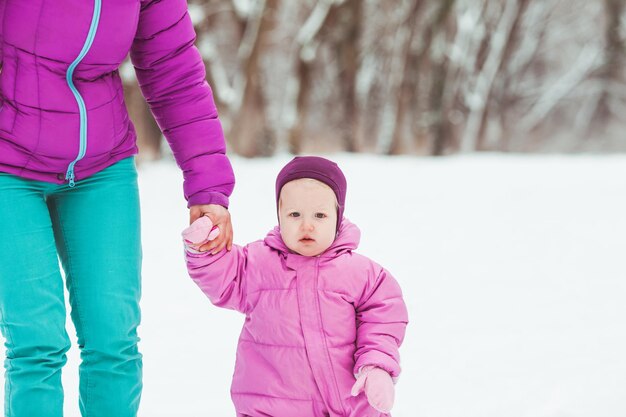 Maman Avec Entendre Une Petite Fille Marche Dans Le Parc D'hiver