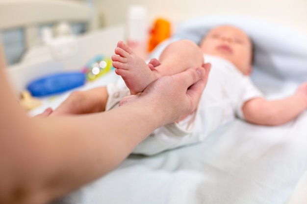 Maman Fait De L'exercice Enfant Souriant. Bébé Nouveau-né Profite D'un Massage De La Mère