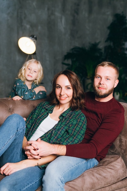 Maman de famille mignonne, papa et fille posent à l'arbre de Noël