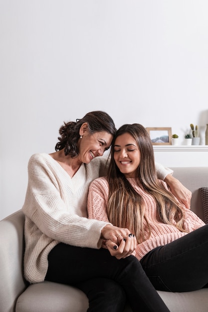 Maman et fille sur canapé, main dans la main