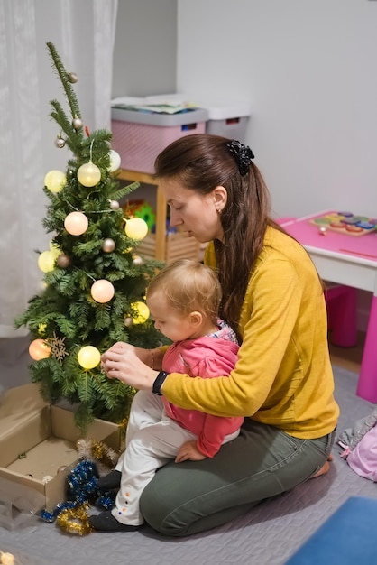 Maman et fille décorent le sapin de Noël à la maison