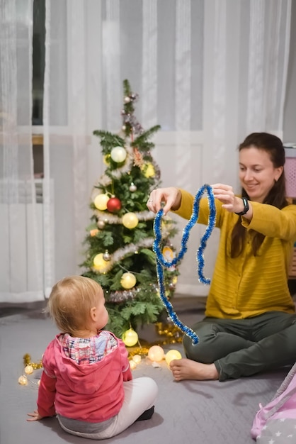 Maman et fille décorent le sapin de Noël à la maison