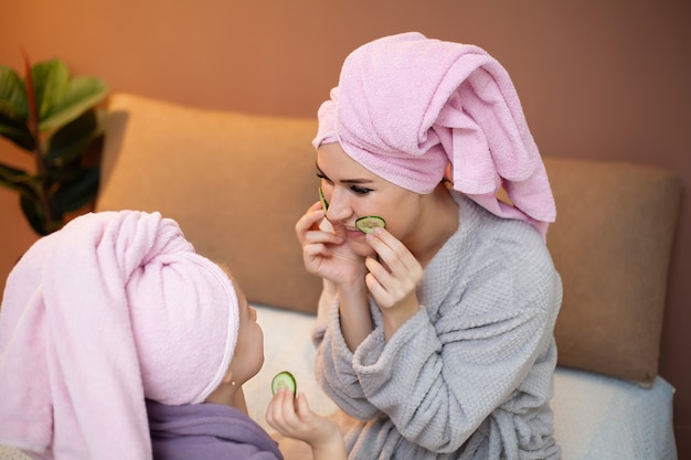 Maman et fille faisant des soins de spa à la maison.