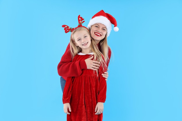 Maman et fille sur fond bleu, concept de Noël