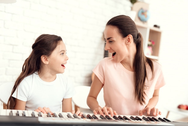 Maman et fille jouent ensemble au synthétiseur.