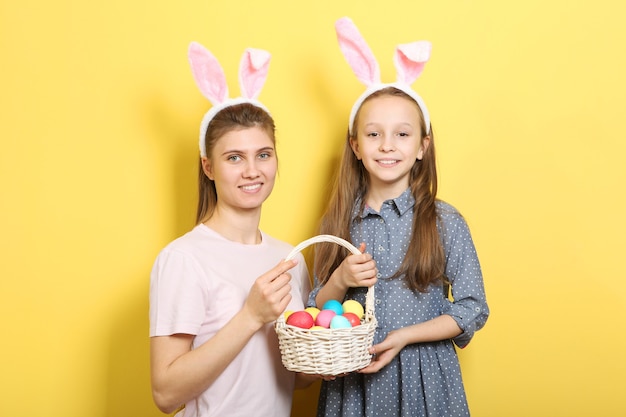 Maman et fille avec des oreilles de lapin sur un fond coloré