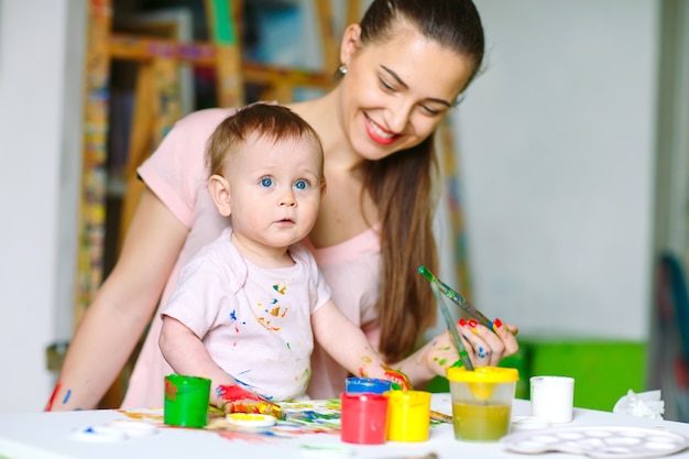 Maman et fille peignent sur toile à l'école de dessin.