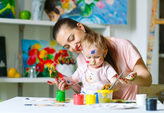 Maman et fille peignent sur toile à l'école de dessin.