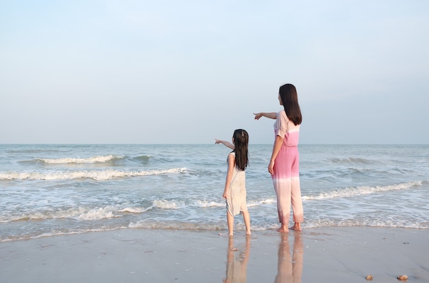 Maman et fille pointant quelque chose à la recherche dans la mer