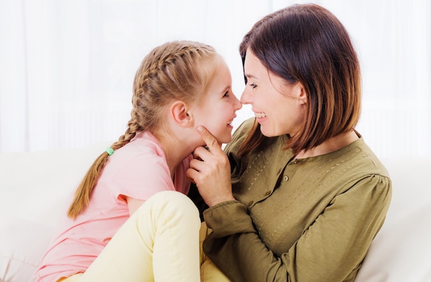 Maman et fille se détendre sur le canapé