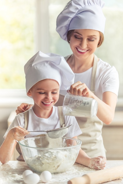 Maman et fille sourient en préparant la pâte