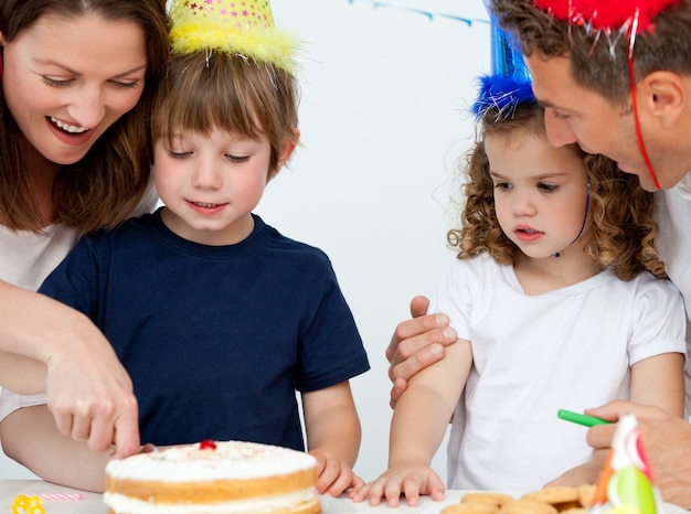 Maman et fils coupant un gâteau d&#39;anniversaire ensemble