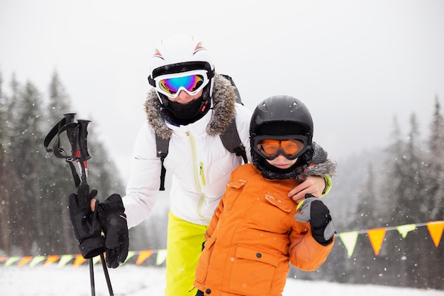 Maman et fils en équipement de ski sur la piste de ski