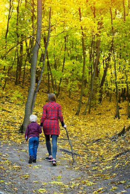 Maman et fils marchant dans la forêt d'automne Vue arrière