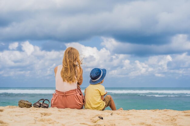 Maman et fils voyagent sur l'étonnante plage de Melasti aux eaux turquoises, île de Bali en Indonésie. Voyager avec le concept des enfants