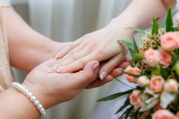 Maman garde sa fille par la main le jour du mariage.