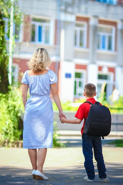 Une Maman Heureuse Conduit L'enfant à L'école Sur Le Chemin Du Retour à L'école