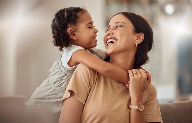 Maman heureuse avec une petite fille câlin à la maison et le temps de jeu du week-end pour maman parent Drôle enfant fou dans le salon mère tenant un tout-petit avec sourire et amour se liant le jour de la fête des mères