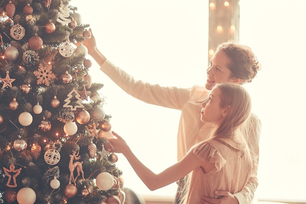 Maman heureuse et petite fille décorant l'arbre de Noël