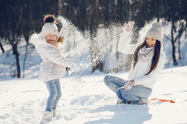 maman jeune et élégante, jouant avec sa petite fille mignonne dans le parc de neige de l&#39;hiver