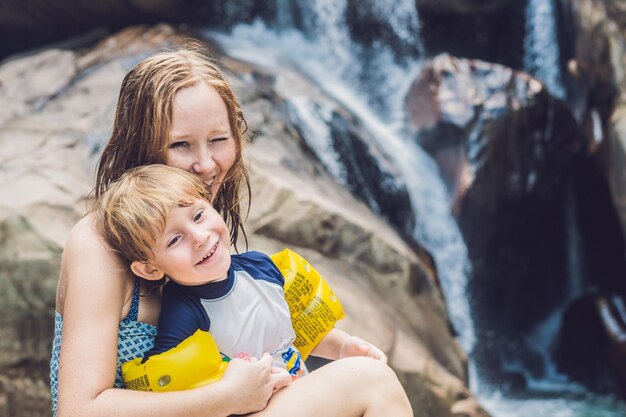 Maman et jeune fils sur le fond de la cascade. Voyager avec le concept d'enfants.