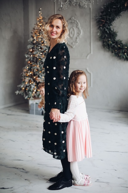 Maman et jolie fille posant le jour de Noël