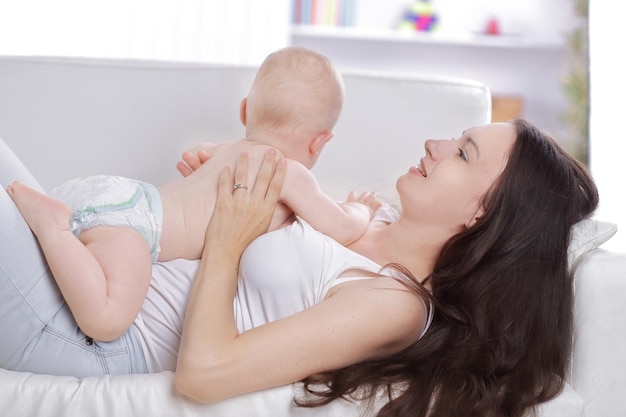 Maman joue avec bébé sur le canapé