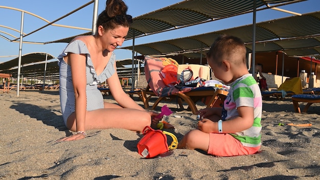 Maman joue avec l'enfant en vacances près de la mer