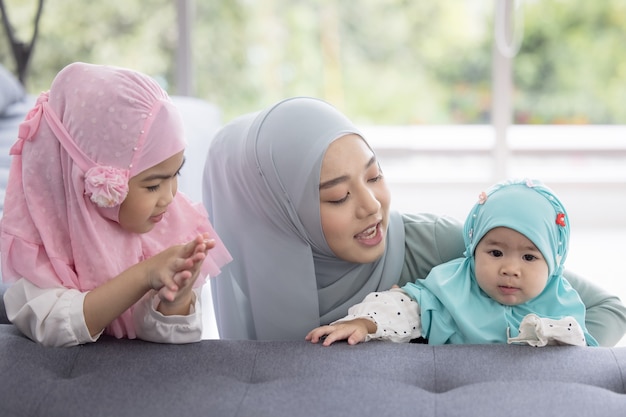 Maman Musulmane En Hijab Est Sa Petite Fille Assise Dans Le Salon, Relation Amoureuse