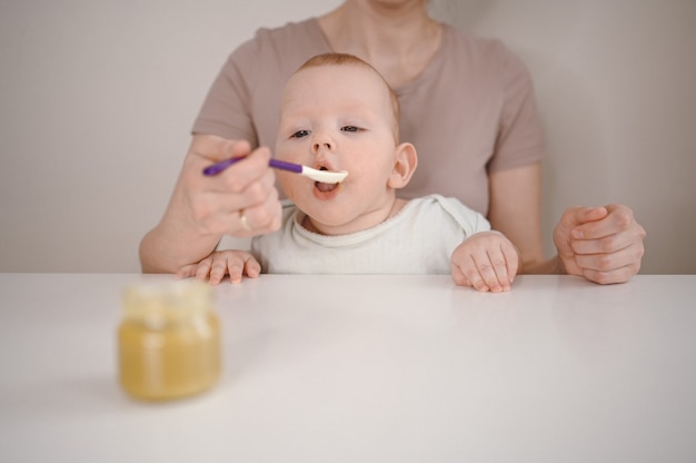 Maman nourrit de la purée à un nouveau-né.