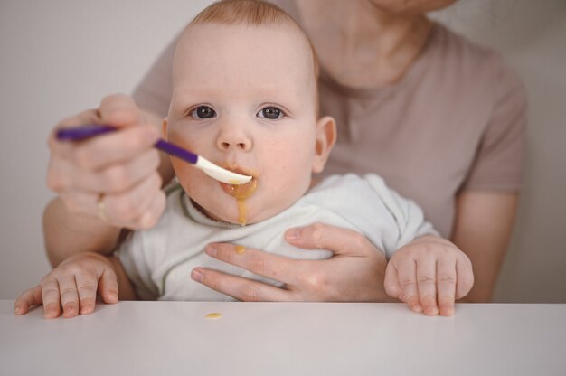 Maman nourrit de la purée à un nouveau-né.