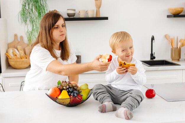 Maman oblige l'enfant à bien manger maman essaie d'apprendre à son enfant à manger sainement alimentation réductrice