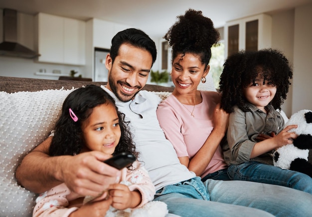 Maman papa et enfants heureux sur le canapé en regardant la télévision et la famille se lient dans le salon Souriez le bonheur et les parents se détendent avec les enfants sur le canapé en streaming abonnement à une émission de télévision ou des films