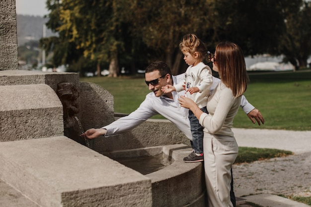 Maman, papa et fille près de la fontaine