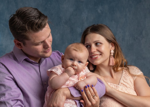 Photo maman et papa tiennent un nouveau-né dans leurs bras jeune famille et petite fille